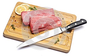 Fresh tuna Fish steak on a wooden cutting serving board isolated on a white background