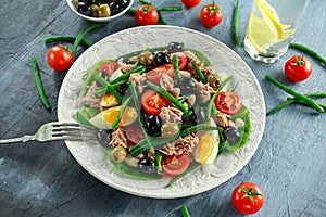 Fresh Tuna Green Bean salad with eggs, tomatoes, beans, olives on white plate. concept healthy food
