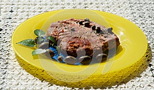 Fresh tuna served with olives, kappar on yellow plate