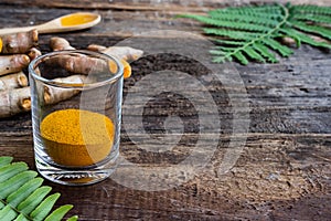 Fresh turmeric and powder curcumin on old wooden background