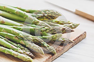 Fresh uncooked asparagus on a wooden cutting board. Close up view