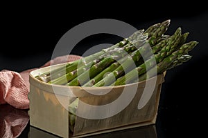 Fresh uncooked green asparagus on black background