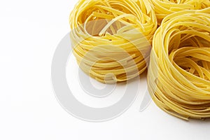 Fresh uncooked tagliolini pasta isolated on a white background