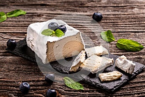 Fresh Valencay cheese. goat cheese Valencay with berries on a slate board rustic background