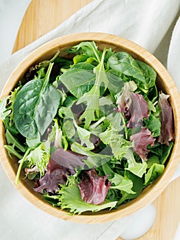 Fresh variety of salad greens in brown bowl