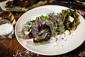 Fresh vegan salad. Avocado, couscous, melon, portobello, soybean, tofu on white plate. Delicious healthy mixed greens