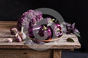 Fresh vegetable. Dark purple peppers, cauliflower with leaves of basil and garlic