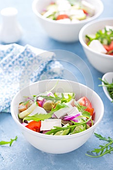 Fresh vegetable salad with feta cheese and olives in white bowl