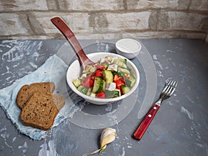 Fresh vegetable salad with feta cheese, two slices of bread