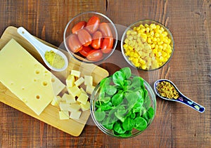 Fresh vegetable salad ingredients, sweet corn, lamb`s lettuce, cheese, chilly and tomatoes