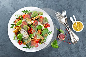 Fresh vegetable salad plate of tomatoes, spinach, pepper, arugula, chard leaves and grilled chicken breast. Fried chicken meat, fi