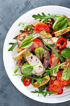 Fresh vegetable salad plate of tomatoes, spinach, pepper, arugula, chard leaves and grilled chicken breast. Fried chicken meat, fi