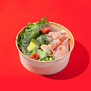 Fresh vegetable salad with slices of ham , cherry tomatoes, avocado, mix lettuce leaves. Ham salad. Take away food. Isolated