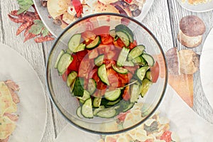 Fresh vegetable salad of tomatoes and cucumbers in a glass bowl