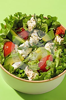 Fresh vegetable salad with tomatoes, cucumbers,  mix lettuce leaves. Green summer salad with feta and cherry tomato. Healthy food