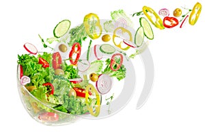 Fresh vegetable salad in transparent bowl with flying ingredients isolated on white. Healthy eating