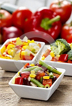 Fresh vegetable salad in white bowl. Spring party table.