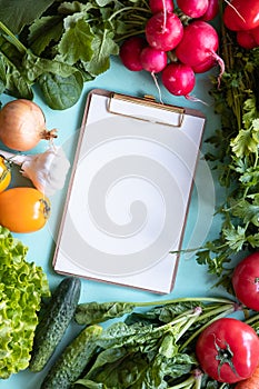 Fresh vegetables around white desk on blue background. Healthy concept. Copy space.