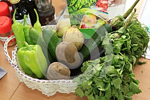 fresh vegetables . In the basket are peppers, cucumbers, onions, potatoes, greens, pickles, eggplant