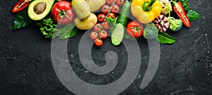 Fresh vegetables on a black background. Avocados, tomatoes, potatoes, paprika, citrus. Top view.