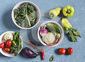 Fresh vegetables - broccoli, peppers, tomatoes, eggplant, squash, turnips on a blue background, top view.