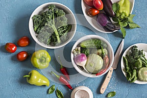 Fresh vegetables - broccoli, peppers, tomatoes, eggplant, squash, turnips on a blue background, top view.