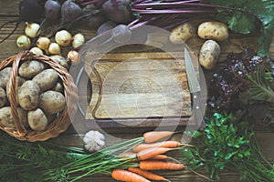 Fresh vegetables from carrot, beetroot, onion, garlic, potato on old board. Top view. Fall. Copy space on cutting board.