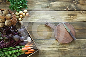 Fresh vegetables from carrot, beetroot, onion, garlic, potato on wooden board. Top view. Autumn still life. Copy space.