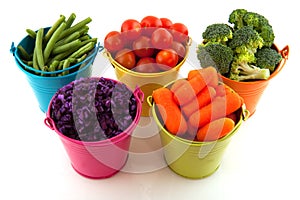 Fresh vegetables in colorful buckets photo