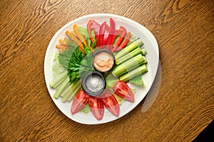 Fresh vegetables (cucumbers, tomatoes, dill, shallots) on a white plate