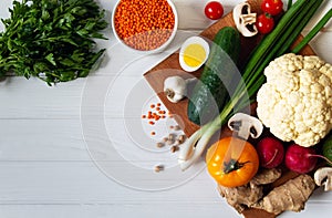Fresh vegetables on a cutting board with greens and lentils on a light background. Diet Food Top View