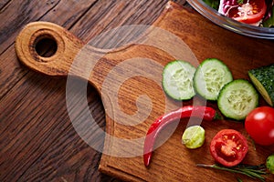 Fresh vegetables on the cutting board over wooden background, selective focus, shallow depth of field