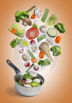 Fresh vegetables flying in a pot, isolated on orange background - image