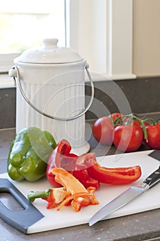 Fresh vegetables, food scraps and compost container on kitchen counter. Sustainable home lifestyles photo