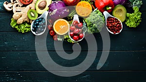 Fresh vegetables and fruits on a black background. Vitamins and minerals. Top view.