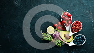 Fresh vegetables and fruits on a black background. Vitamins and minerals. Top view.