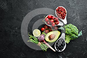 Fresh vegetables and fruits on a black background. Vitamins and minerals. Top view.