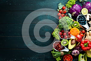 Fresh vegetables and fruits on a black background. Vitamins and minerals. Top view.