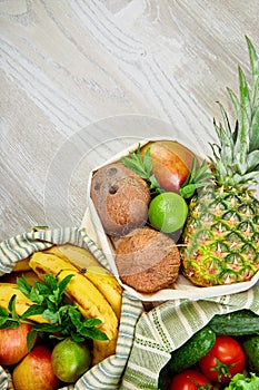 Fresh vegetables and fruits in eco cotton bags on table in the kitchen