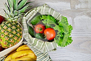 Fresh vegetables and fruits in eco cotton bags on table in the kitchen