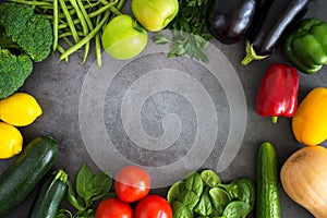 Fresh vegetables, fruits, herbs on dark stone table Frame of fresh veggies. Mockup for menu or recipe. Spring vitamins