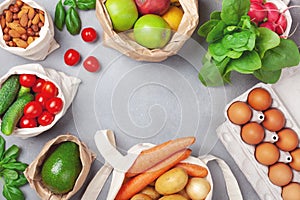 Fresh vegetables and fruits in natural eco friendly cotton and paper bags top view. Zero waste food shopping and plastic free