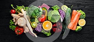 Fresh vegetables and fruits. Organic food on a black wooden background.