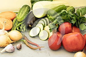 Fresh vegetables on a gray cement background Zucchini Tomatoes Cucumbers Carrots Potatoes String Beans Onion Garlic