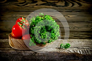 Fresh vegetables and herbs, tomatoes and parsley on a wooden tab