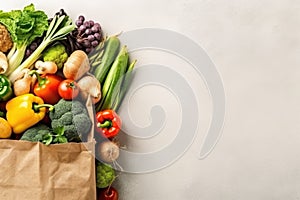 Fresh vegetables, including broccoli, carrots, red potatoes, cauliflower, lettuce, okra, and corn, neatly arranged on wh