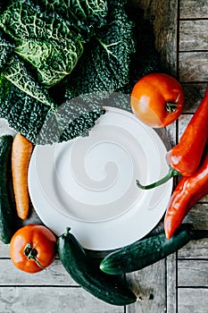 Fresh vegetables: kale, Carrot, pepper, tomato, cucumber around