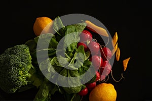 Fresh vegetables lie on black table