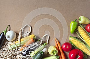 Fresh Vegetables, mesh shopping bag on craft Background. Healthy Food. Vegetarian, Organic Food. Copy space, flat lay