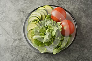 Fresh vegetables in a plate - salad mix, tomatoes and zuchinni. Healthy food concept, lose weight